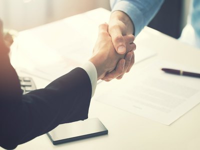 Geschäftsleute schütteln sich nach der Unterzeichnung des Partnerschaftsvertrags die Hände