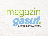 Text auf weißem Hintergrund: "magazin" in grün und "gasuf" in blau. Darunter steht: "Energie. Wärme. Zukunft." Die Komposition vermittelt Themen rund um Energie und nachhaltige Zukunft.