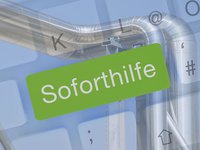 Eine große grüne Fläche mit dem Text "Soforthilfe" in Weiß steht im Vordergrund. Im Hintergrund sind glänzende Metallrohre zu sehen, die zum industriellen Umfeld gehören. Der Hintergrund hat auch verschwommen Symbole einer Tastatur.