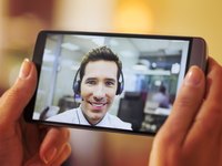 Weibliche Hand, die ein Smartphone während eines Videos-Chats hält