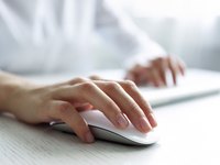 Weibliche Hand mit Computermaus auf Tisch, Nahaufnahme