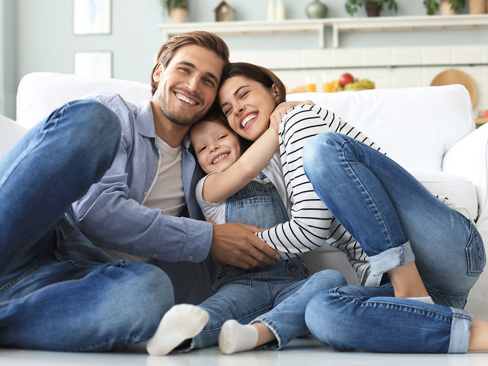 Junge Familie mit kleinen Tochter entspannen auf dem Boden im Wohnzimmer.